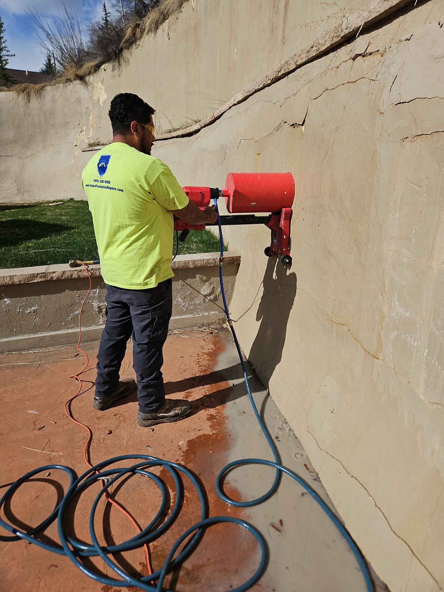 Aspen Foundation Repairs technician core drilling a retaining wall for new weep drains