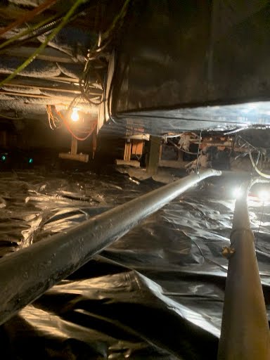 Drainage pipes carrying water out of an encapsulated crawl space