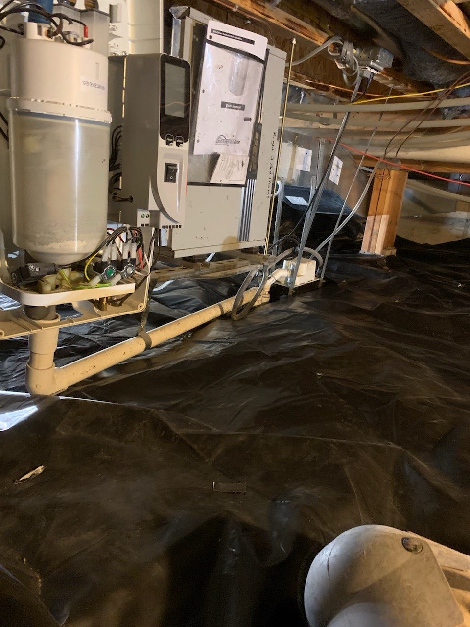 Crawl space drainage line run across a sealed vapor barrier past a dehumidifier
