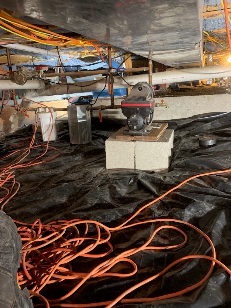 Crawl space sump pump set on a block base inside the sealed liner