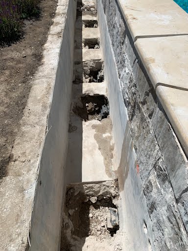 Close-up of footing notches dug for pier installation at a pool