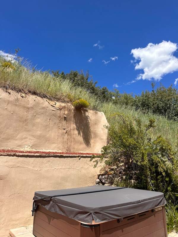 Eroding slope above a retaining wall with soil washed out at the top of the wall