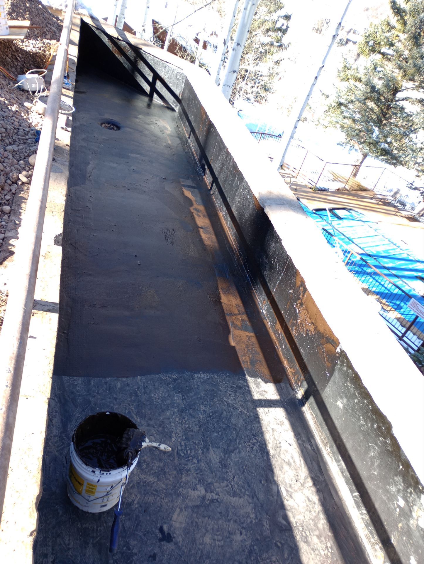 Waterproof membrane coating a cleaned basement wall