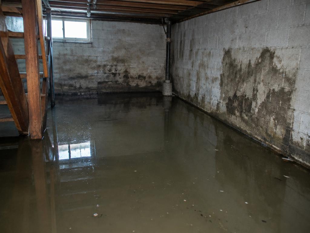 Flooded basement with water-stained block walls